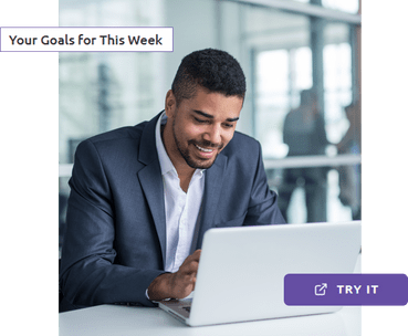 A man smiling while using his laptop